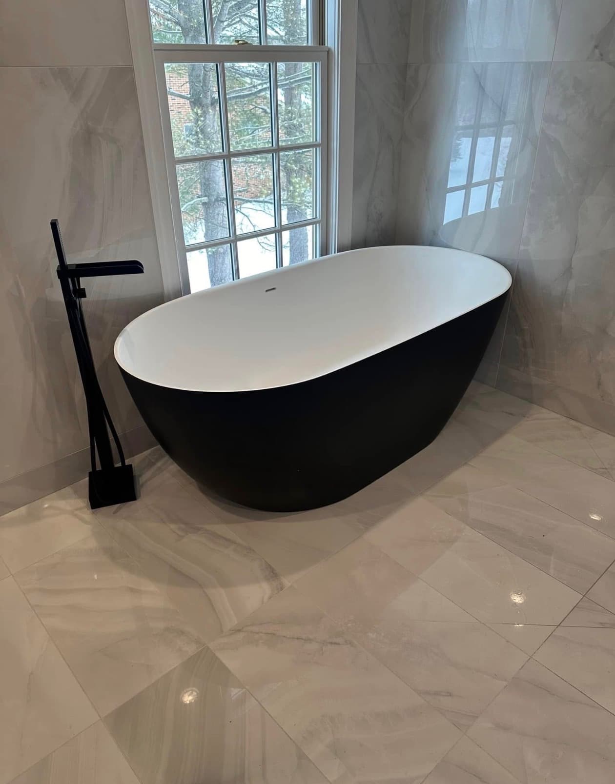 Freestanding tub and floor-mounted filler in a finished bathroom remodel