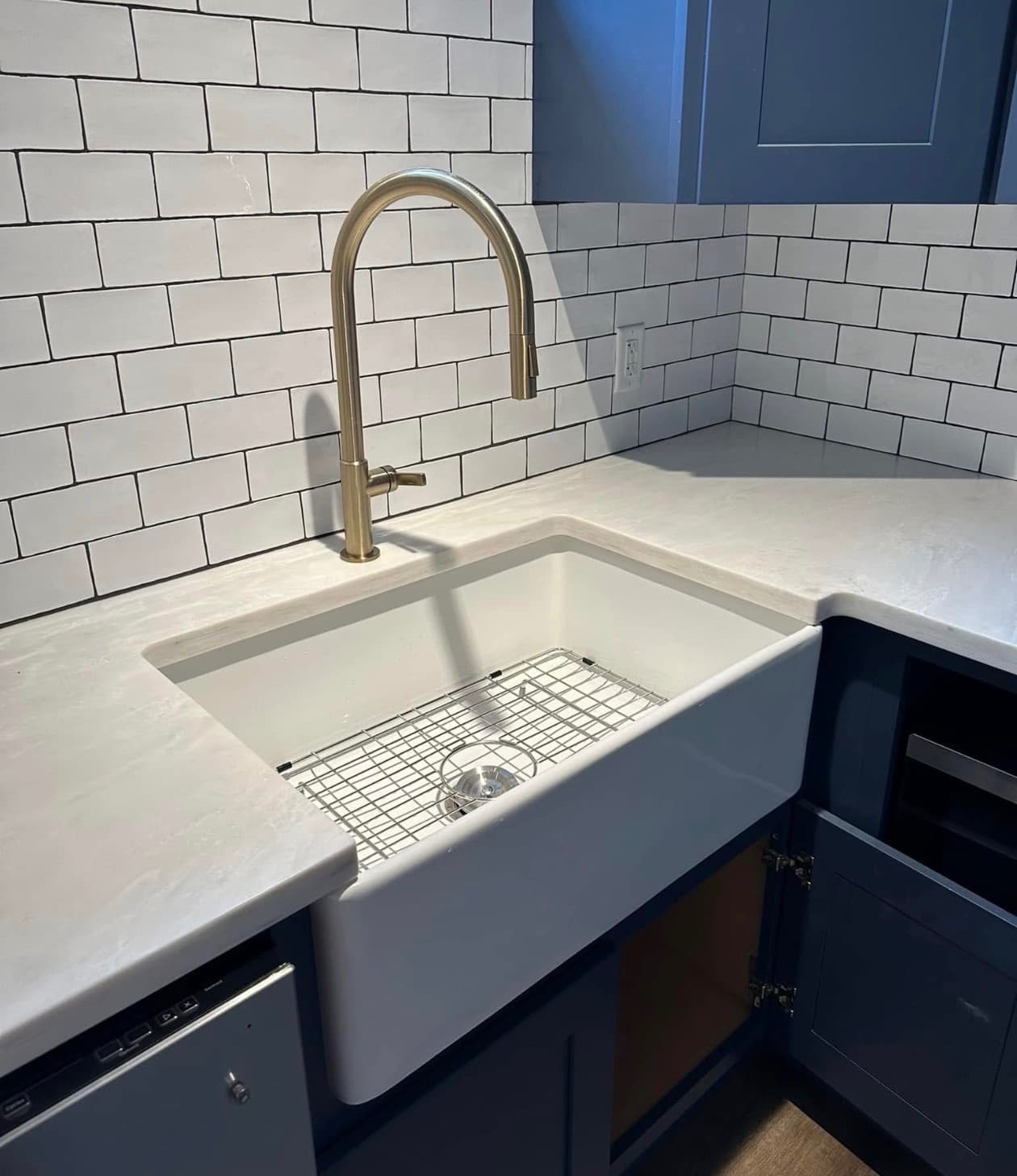 Farmhouse sink and pull-down faucet installed in a kitchen